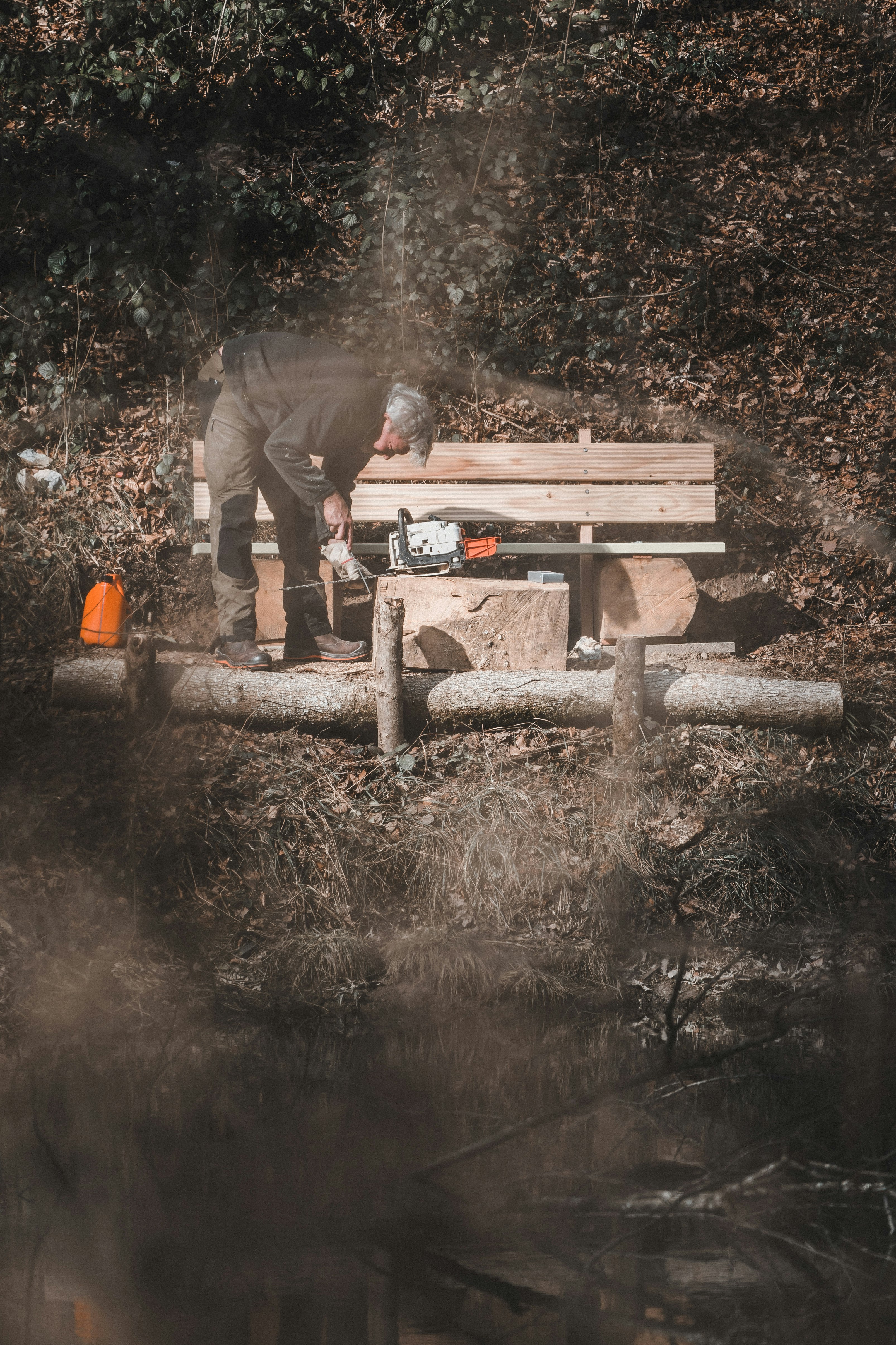 man in green jacket and brown pants standing on brown wooden log